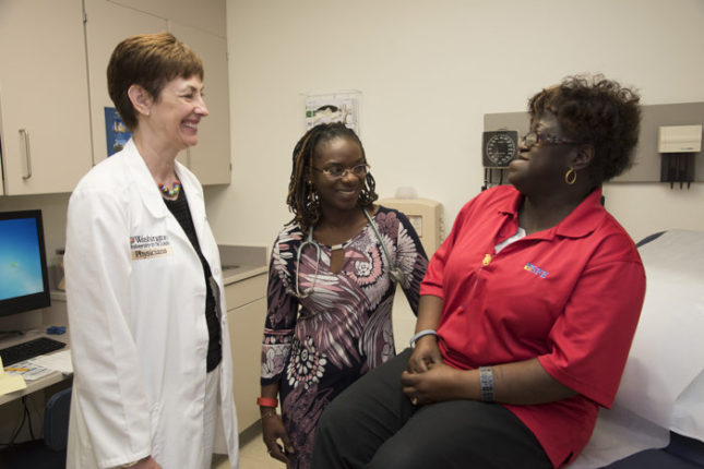  Laura Jean Bierut, MD (left), and Foluso Ademuyiwa, MD (center), discuss genetic risks for breast cancer with patient Delores Ford-Dixon. Robert J. Boston photograph 